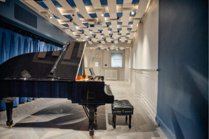 blue acoustic panels on ceiling in open room with piano in foreground