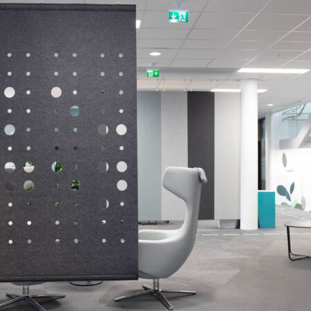 grey felt screen with circles cutout hanging in office