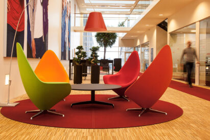 red circular felt rug under designer chairs in hallway