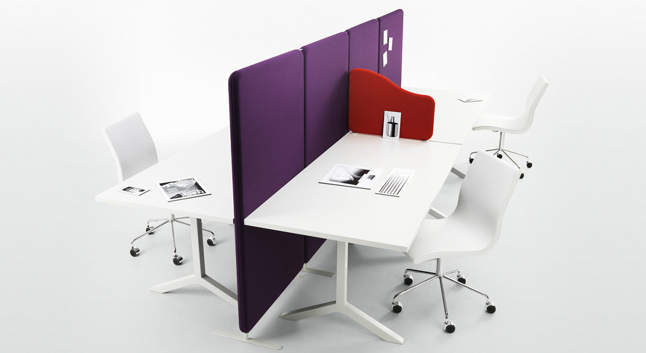purple acoustic floor screens dividing two white desks