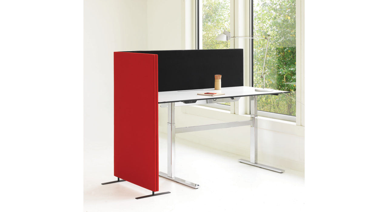 red and black acoustic screens on desk near window