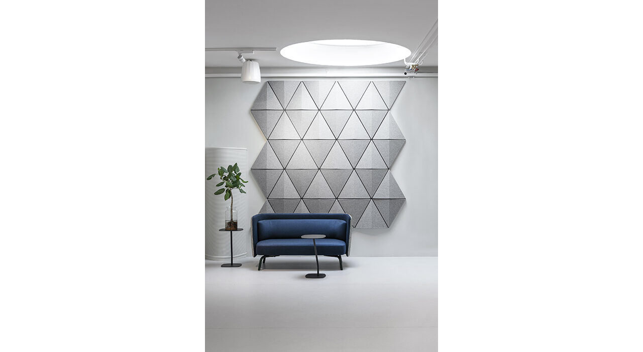 grey triangular acoustic tile on wall behind sofa