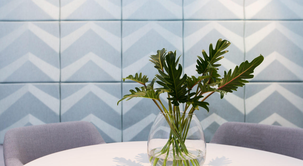 light grey acoustic wall tiles with a chevron pattern behind plant on table