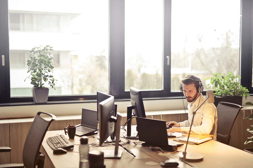 man working on his computer with headphones