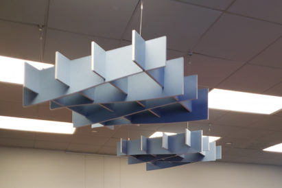two sound absorbing light blue baffles suspended from an office ceiling