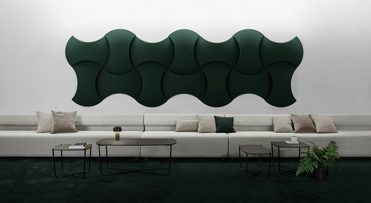 dark green sound-absorbing tiles on wall above large sofa