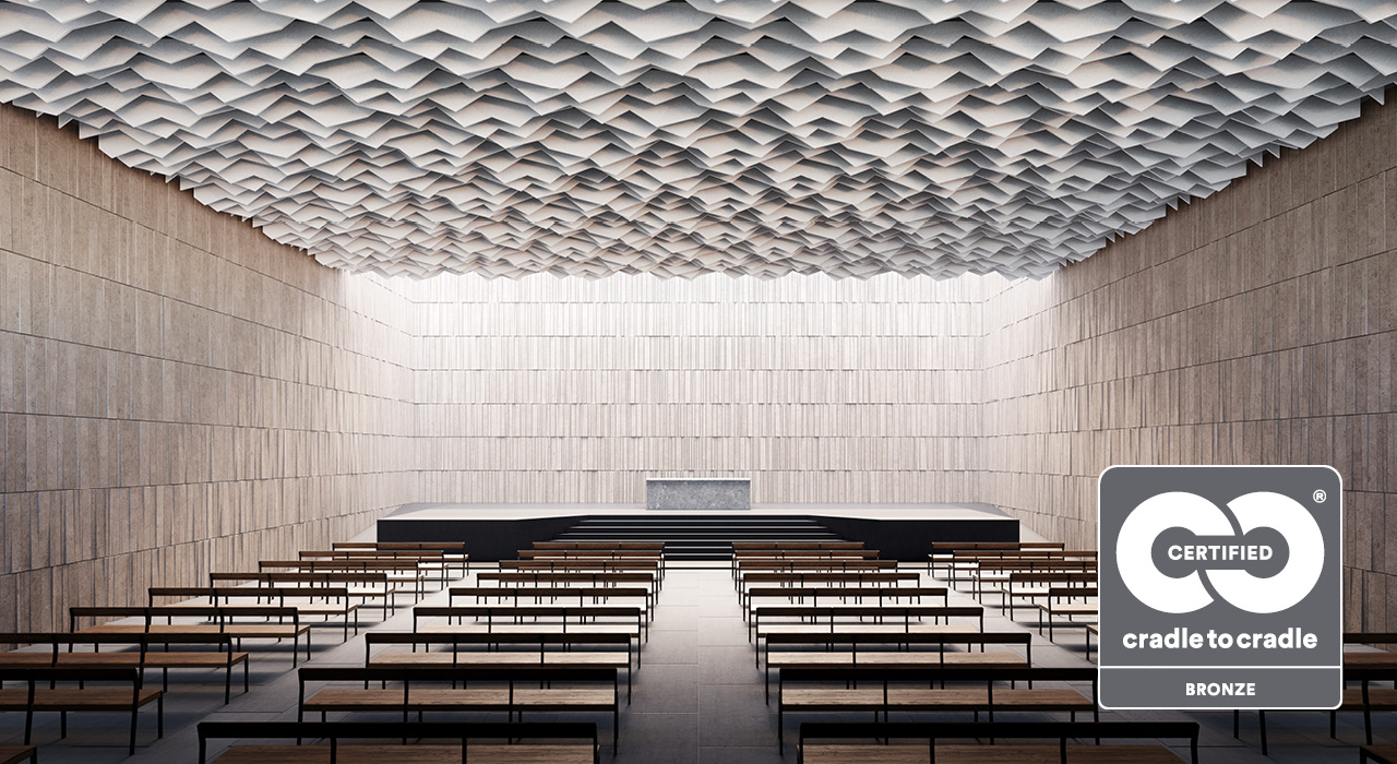 beige triangular shaped acoustic baffles suspended above auditorium with cradle to cradle logo