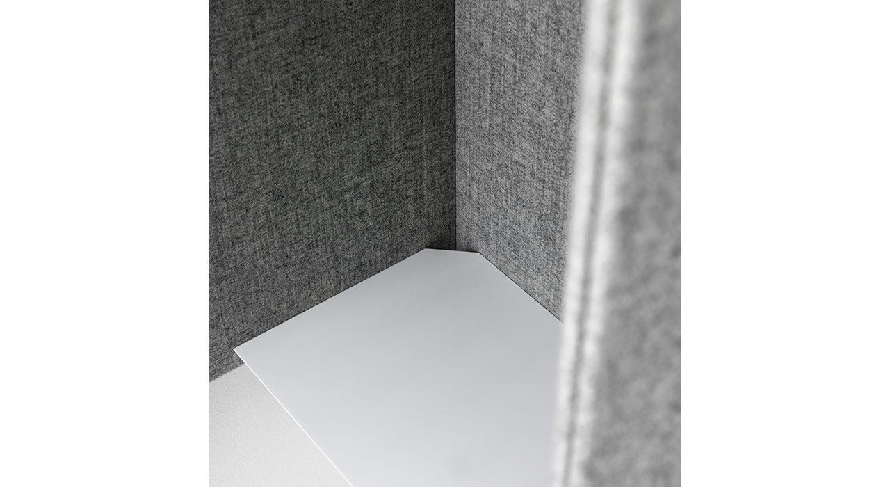 detail of grey sound absorbing booth with white shelf