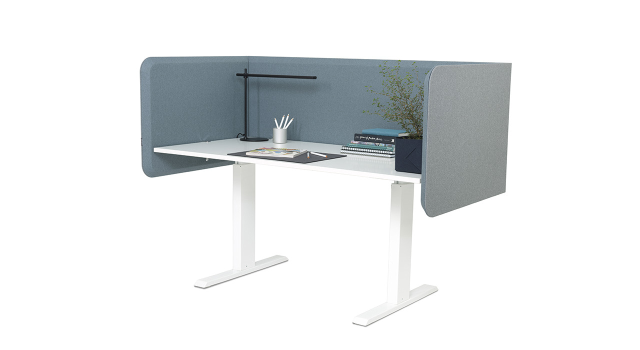 fully surrounded acoustic table screen at desk with plant and lamp
