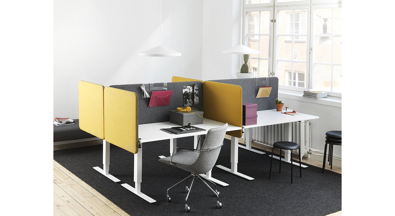 yellow and grey acoustic table screens on white desks in office with large window