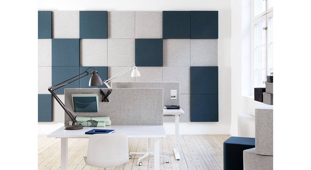 grey acoustic screens on white tables in office with sound absorbing wall tiles