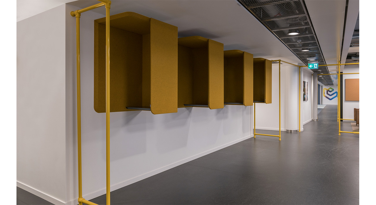 four yellow acoustic wall booths in hallway of office