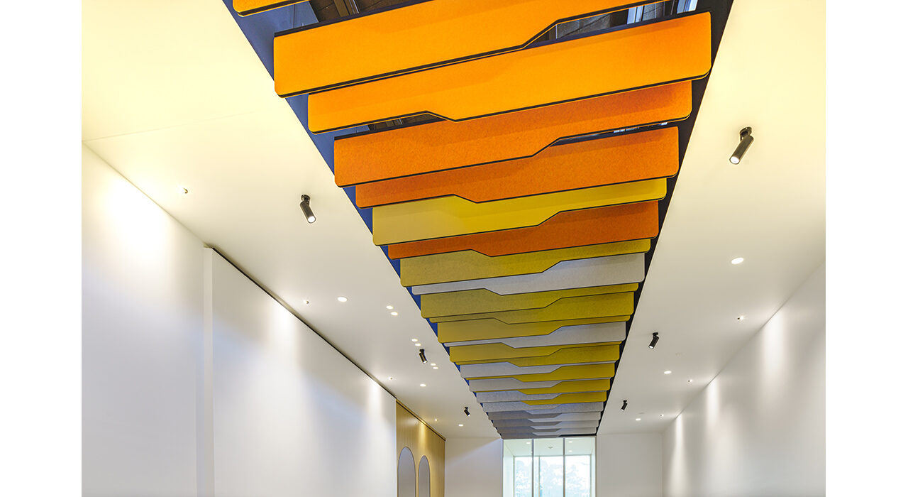 detail of orange yellow and white baffles above office reception area