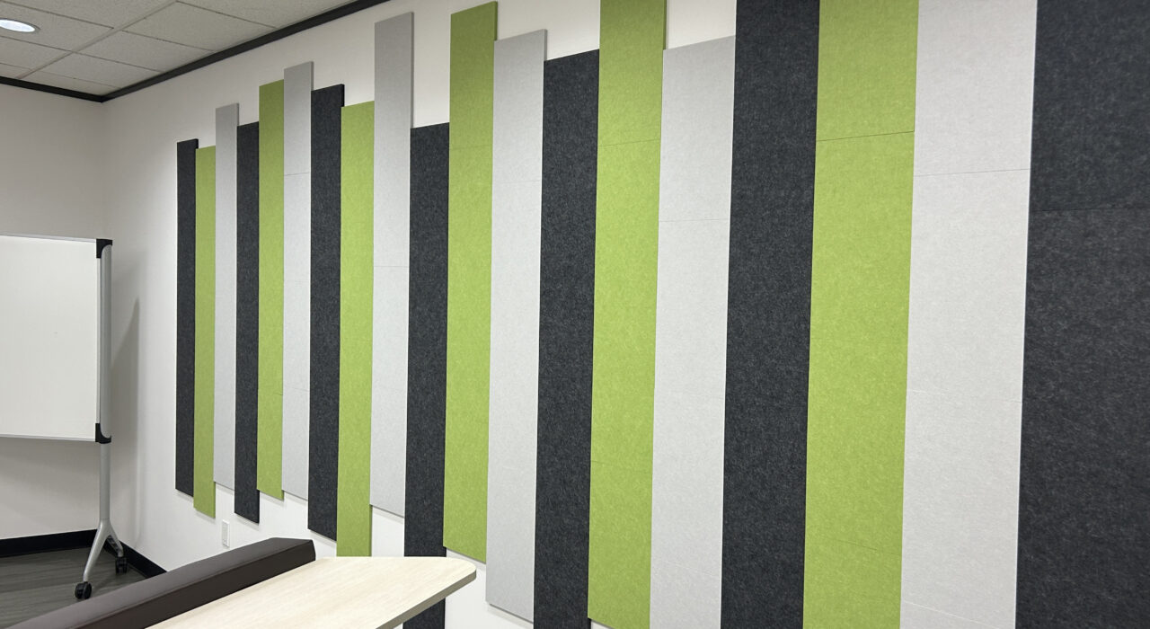 multi-colored Design Studio acoustic tiles arranged in a linear fashion on wall above a bench