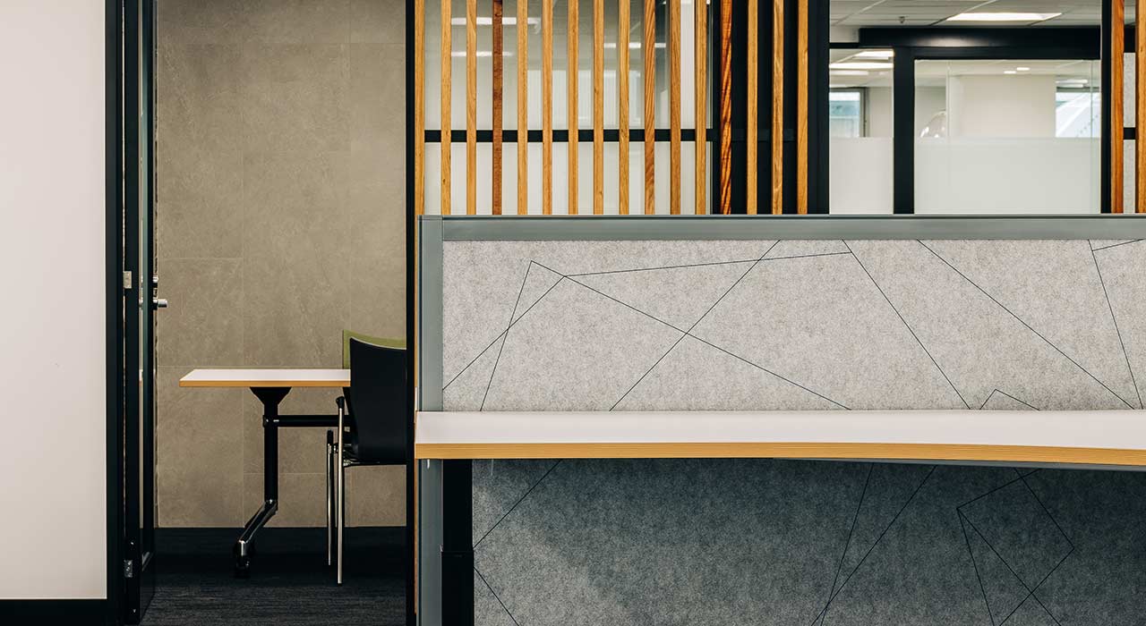linear design on sound-absorbing light grey screen panels in office partition