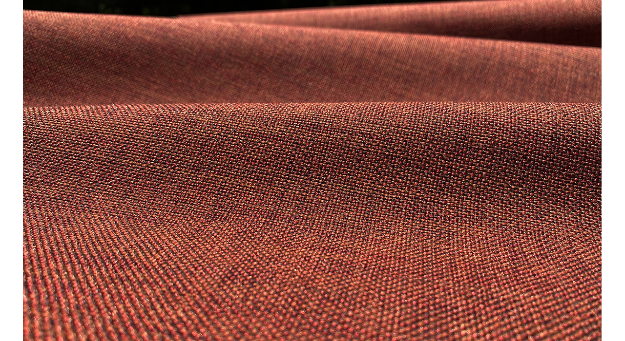 warm reddish orange textured upholstery fabric in dramatic lighting