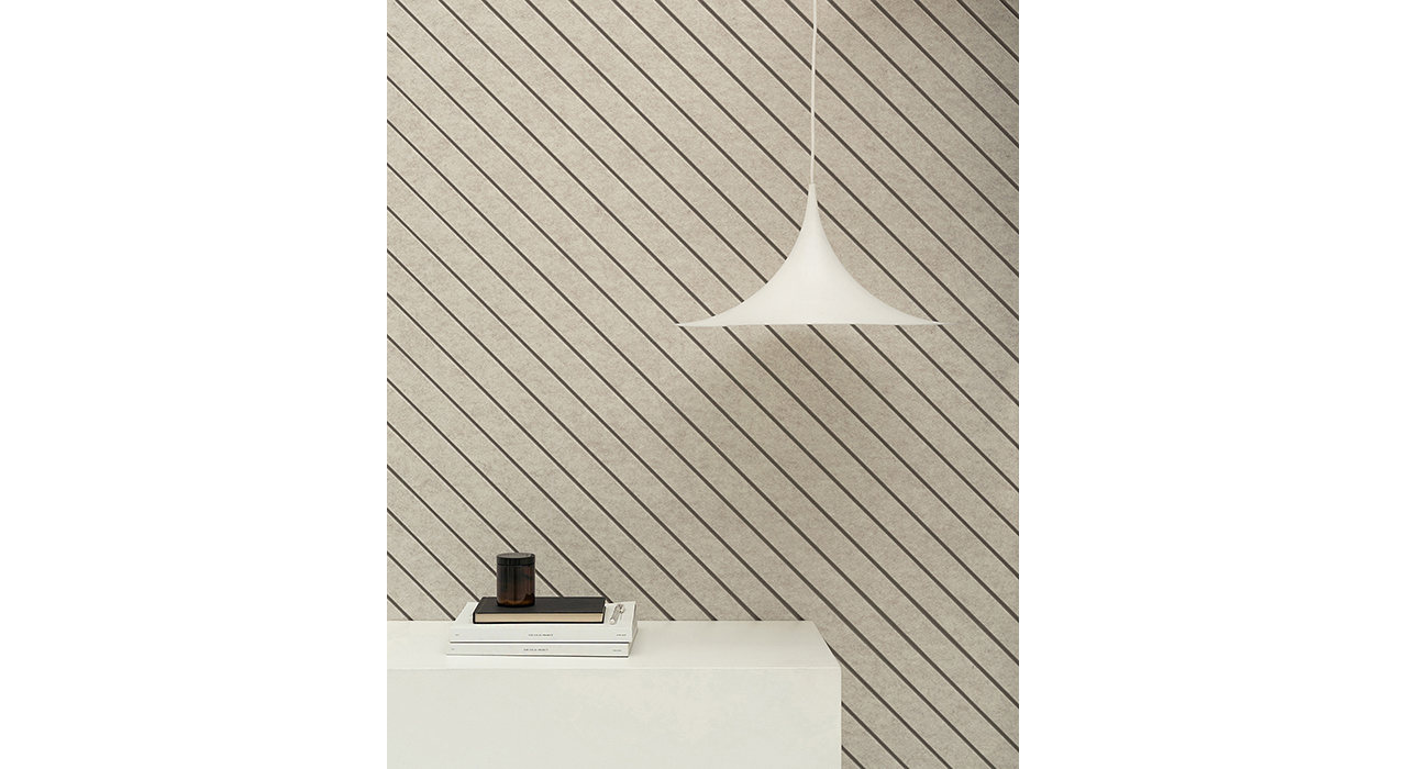 tan sound-absorbing wall panels with diagonal line design behind white table with books and hanging sconce
