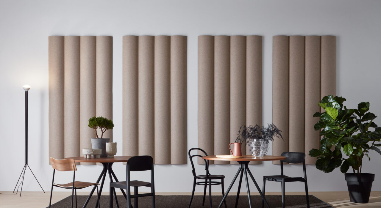 tan sound absorbing scala xl convex tiles on wall behind tables and chairs with plant