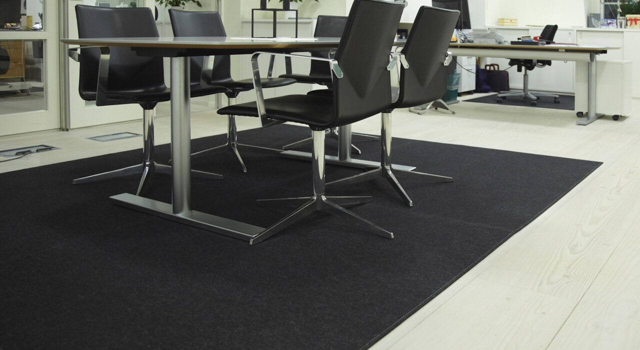 rectangular wool felt rug with light stitching pattern under table in office