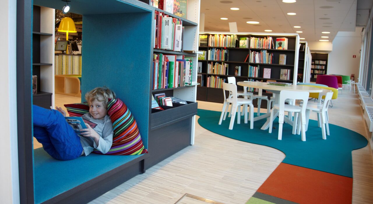 child relaxing and reading on sound absorbing Fraster wool felt rug in library