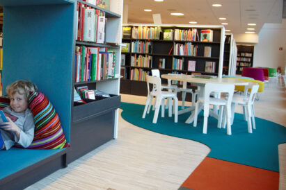 child relaxing and reading on sound absorbing colorful Fraster felt rug in library