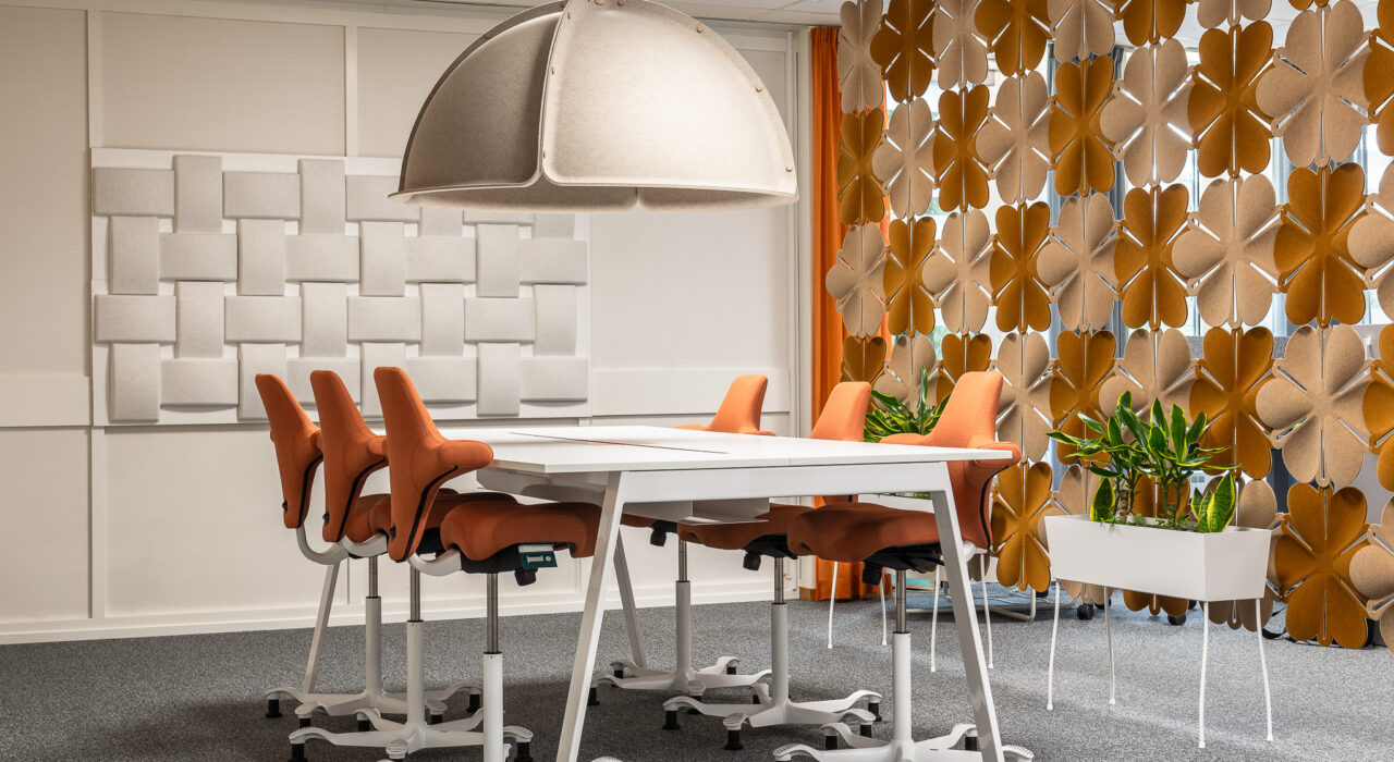 Airflake acoustic hanging screen behind conference table and chairs in an office